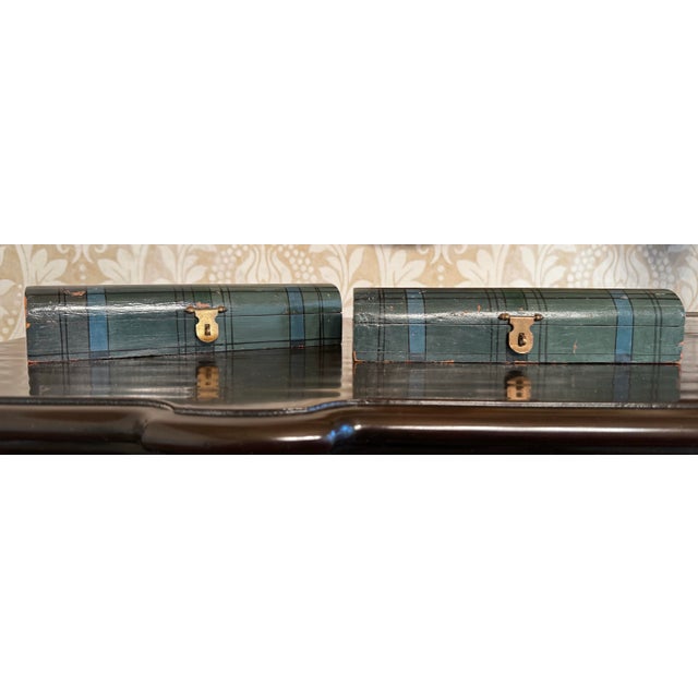 A pair of rectangular, low-profile with a distinct arched lid are painted in a Tartan plaid style of blue, green and black...