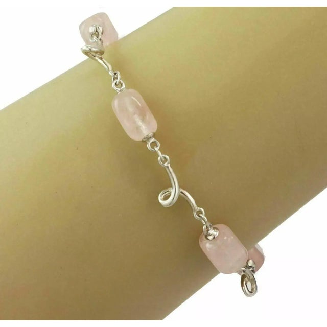 This is an authentic beaded bracelet from Tiffany & Co. It is crafted from sterling silver and has 5 translucent pink rose...