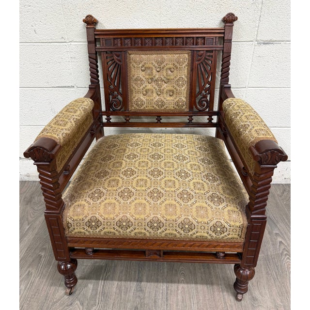 This is a stunning antique Victorian Eastlake library chair, lounge chair, or armchair crafted in walnut, featuring carved...