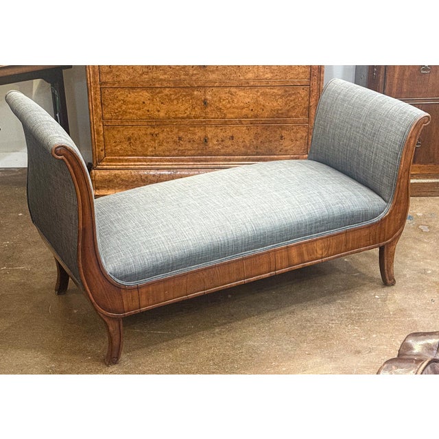 A fine French Empire day bed or window seat from the late 19th century featuring an elegant frame of patinated walnut...
