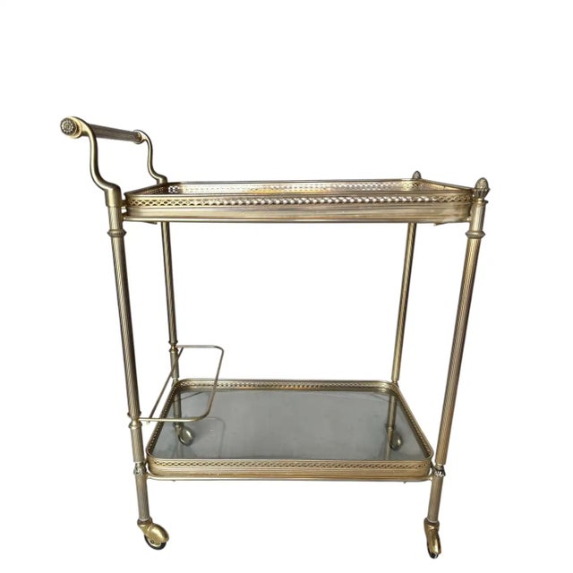 Found in France, this brass and smoked glass bar cart features a pierced brass gallery on both levels. The lower level has...