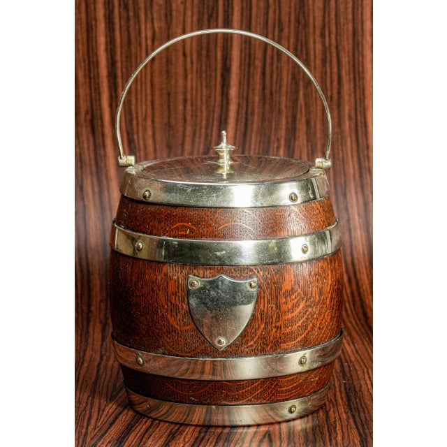 Offered here is a delightful English antique biscuit barrel, beautifully crafted with an oak wood exterior and a porcelain...