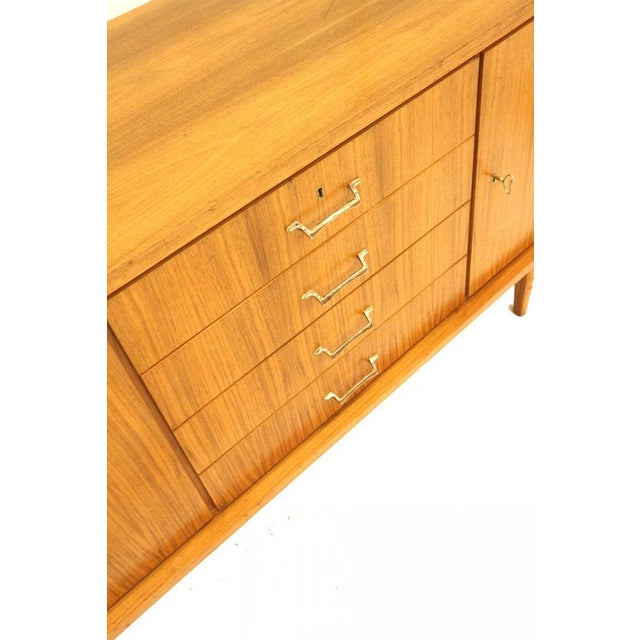 Large vintage sideboard by Musterring from the 1960s. This large sideboard has 4 drawers and 3 doors behind which you can...