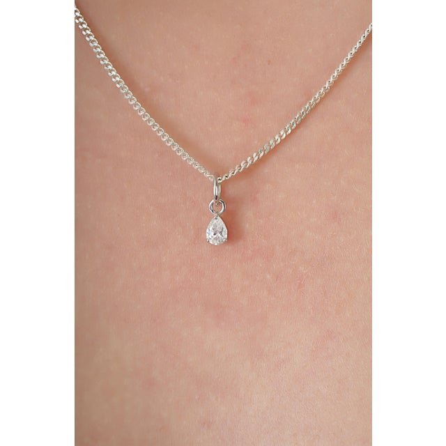 This solitaire pendant features a 0.21 carat pear-shaped diamond set in 14k white gold. The diamond measuring 3.3 x 5 mm,...