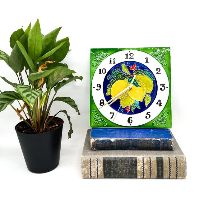 Captivating vintage ceramic wall clock featuring a vibrant hand-painted lemon motif with lush green leaves set against a...