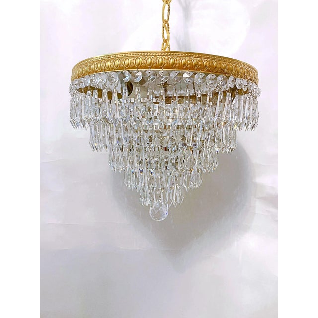 This is an Italian brass rim chandelier dressed with octagon bead and Plug cut crystals. It has 3 candelabra base sockets...