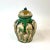 This tri-colored ceramic ginger jar is glazed in a brilliant teal, green, and white. Each “panel” depicts florals and trees.