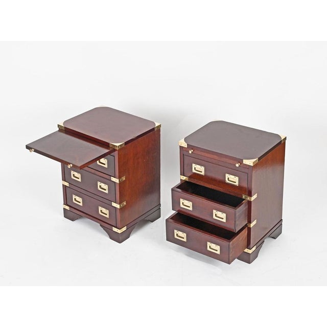 Refined and rare pair of Italian Campaign Style nightstands or side tables in mahogany and solid brass, produced in Italy...