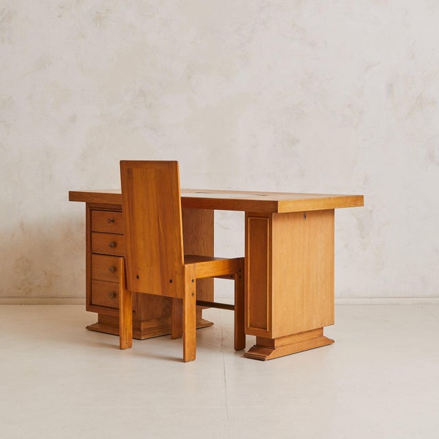 A 1950s French architect’s desk, crafted in solid oak with a warm tone and expressive grain. The rectangular top floats...