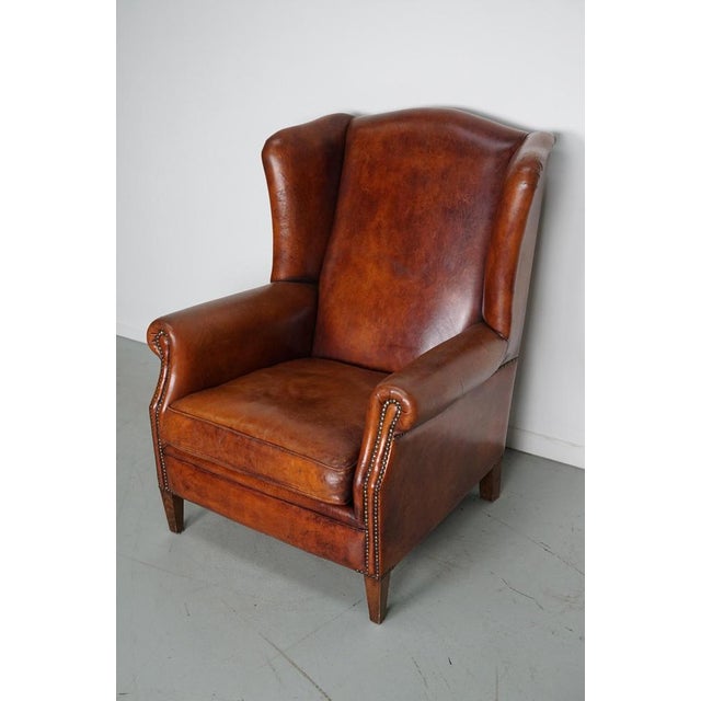 This cognac-colored leather club chair comes from the Netherlands. It is upholstered with cognac-colored leather and...