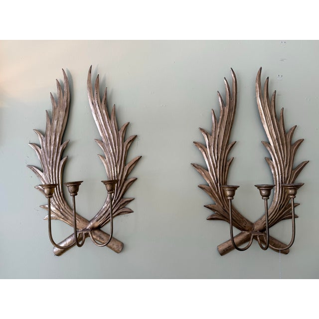 Pair of Hollywood Regency sculptural gilt palm frond candle sconces with an antiqued gold finish, offering a glamorous yet...