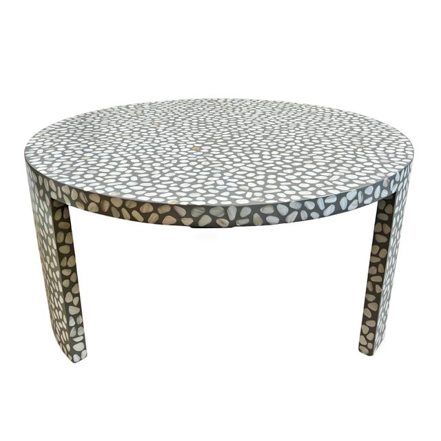 Beautiful vintage round mother of pearl coffee table on grey resin ground. Features organic pebble-shaped mother of pearl...