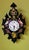 A handcrafted wall clock, lacquered in black and meticulously decorated with hand-painted flowers and exotic birds...