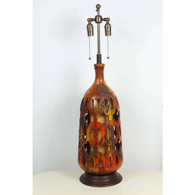 Pair of large ceramic lamps with cutout detailing. The lamps have a wonderful glazed finish and have been newly rewired...