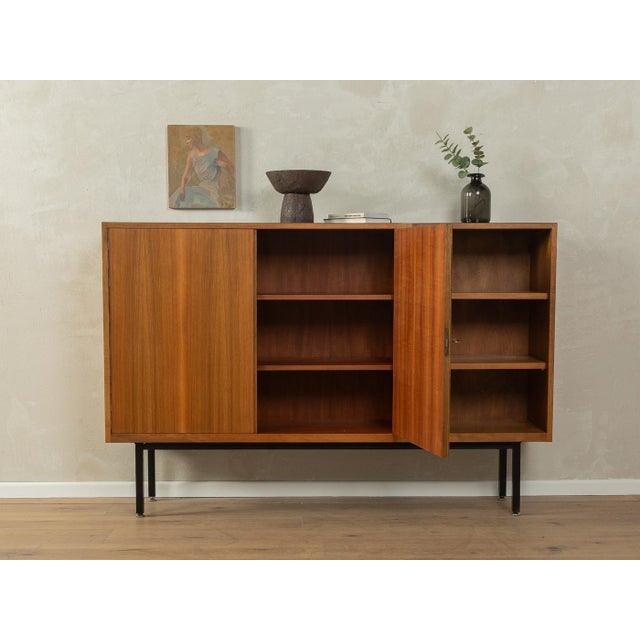 Classic sideboard from the 1950s. Walnut veneer body with two cabinet doors, four shelves, and new black square steel...