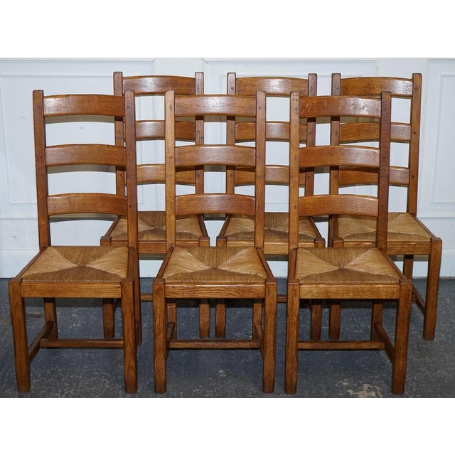 An elegant set of six French ladder-back dining chairs from the 1950s, expertly crafted in solid oak with hand-woven rush...