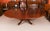 This is a fabulous vintage regency revival flame mahogany jupe circular extending dining table, made by the master cabinet...
