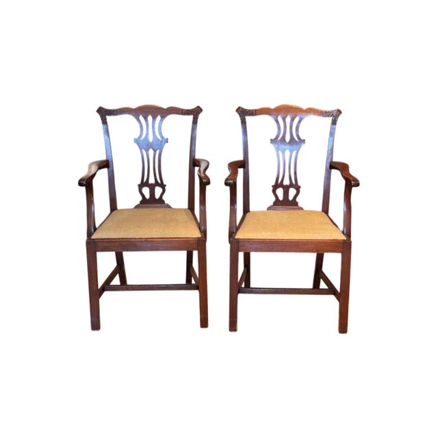 Set of four mahogany armchairs with pierced splats, shaped top rails, and upholstered seats in neutral fabric. Square legs...