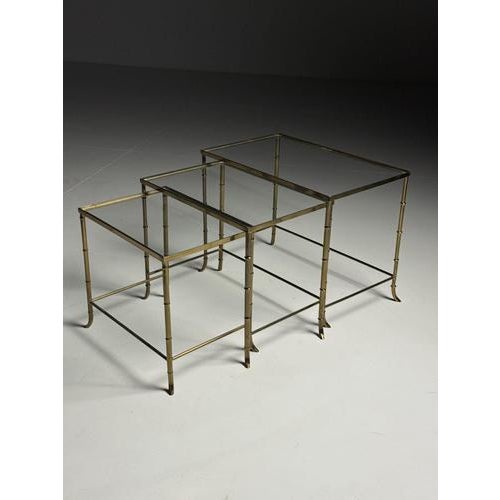 Set of 3 Faux Bamboo Nesting Tables. Gold-colored. Frames in faux bamboo motif. All 3 in good condition. Glass shows only...
