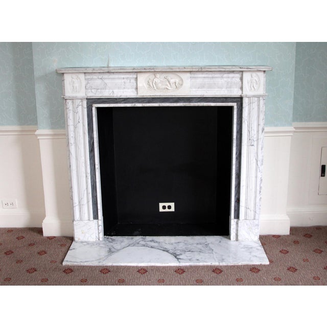 This small scale English Regency style mantel is carved from white marble with rich gray veining. The design of the mantel...