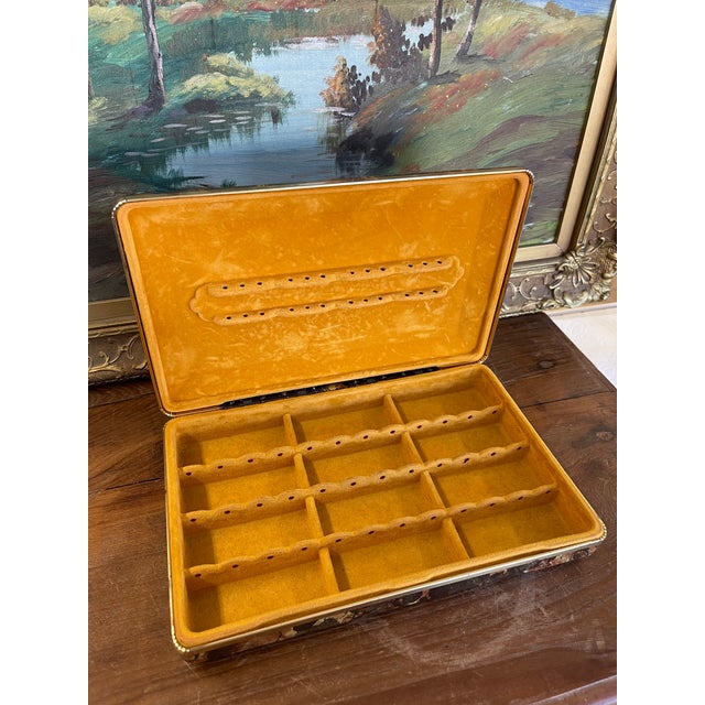 This vintage jewelry case features a striking patterned exterior in warm tones of brown, black, and gold, paired with a...