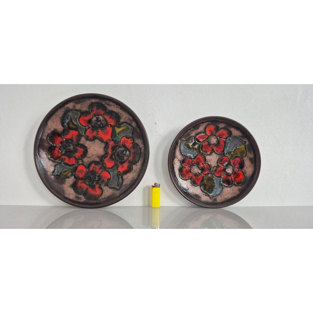 Ruscha plates with a floral design from the 1970s. Very good condition, no damage. Diameters: 22.5 & 27.5 cm. This piece...
