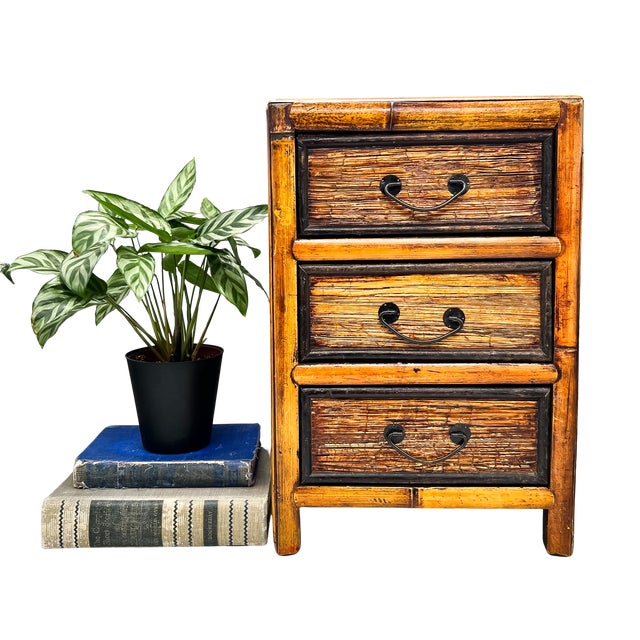 Charming, mid-late 20th century bamboo three-drawer tabletop cabinet featuring warm honey-toned bamboo framing, textured...