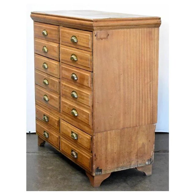 Chest features 14 dovetailed drawers with brass hardware. It is in original vintage condition and unaltered. Top drawer...