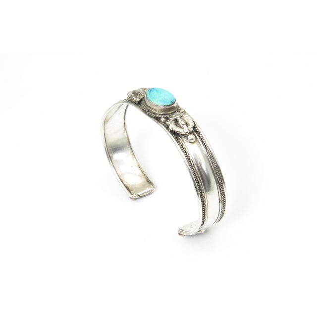 Sterling Silver and Opal Cuff Bracelet A sterling silver cuff bracelet featuring an oval opal cabochon in a smooth bezel...