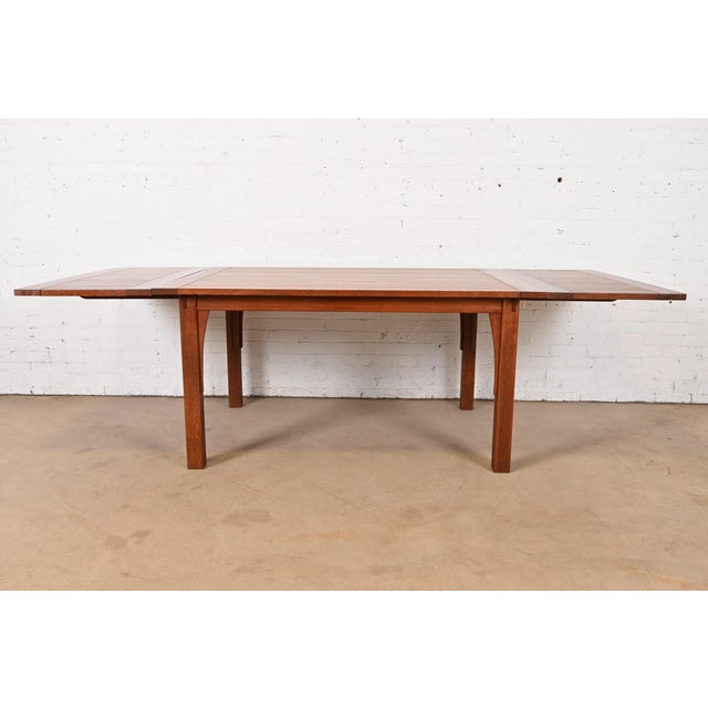 An exceptional Mission or Arts & Crafts style solid oak harvest farm extension dining table with inlaid bowtie design By...