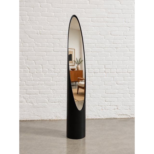 Mid Century Modern vintage full length lipstick mirror with a tall, elongated oval silhouette and a sculptural black body....