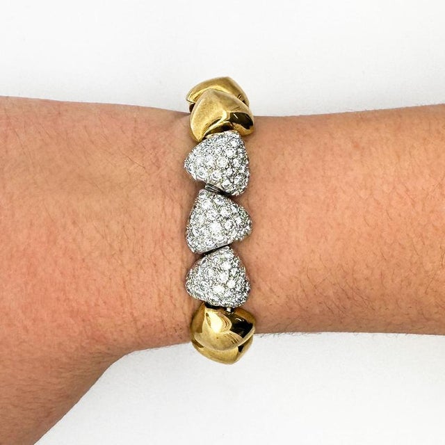 An Italian masterpiece, this 18K yellow gold vintage "Heart Charm" diamond pave bracelet exudes elegance and uniqueness....