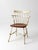 A vintage Ethan Allen comb back chair featuring a classic American silhouette with a warm wood seat and a cream painted...