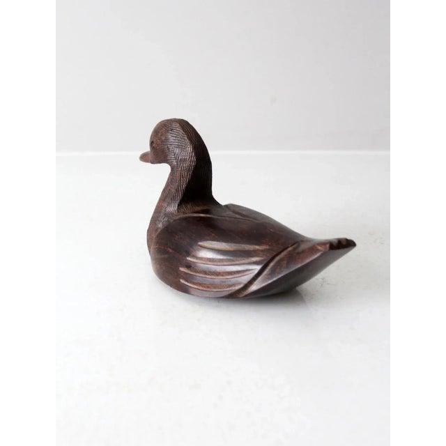This vintage hand-carved ironwood duck figurine features sleek lines with textured detailing around the head. Its rich...