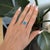 A Cambodian blue zircon blazes with extraordinary brilliance in this elongated cushion ring, accented with diamonds in...