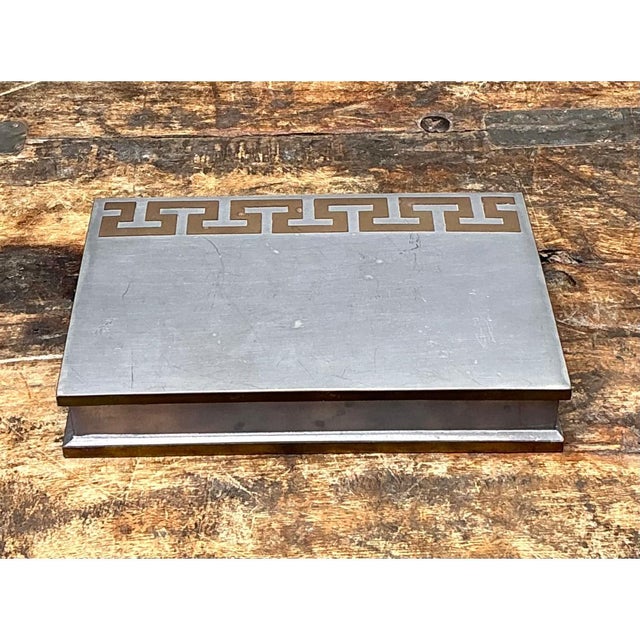 This minimalist yet elegant vintage metal box is crafted from robust metal featuring a muted, silvery sheen and a flat top...