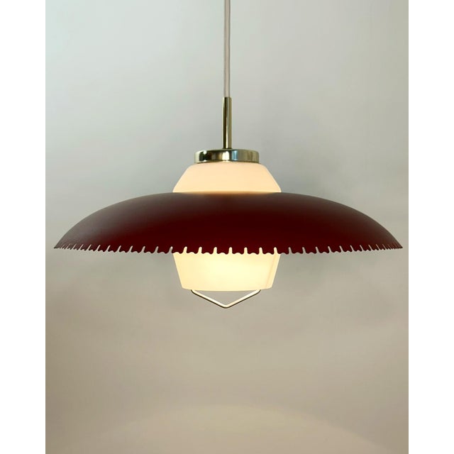 Danish mid-century pendant attributed to Bent Karlby, Denmark, circa 1950s–1960s. Executed in lacquered metal with a...