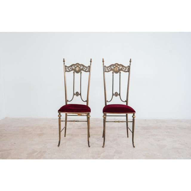 Elegant pair of Pier Luigi Colli-style chairs, iconic of 1950s Italian Mid-Century design. The chairs feature brass frames...