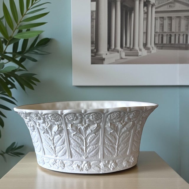 An elegant Italian Neoclassical ceramic cachepot by Tiffany & Co., featuring sculptural raised floral panels with...