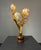 A four-light table lamp in gilt tole, formed as a spray of tulip-form buds rising from sword-leaf foliage, mounted on a...
