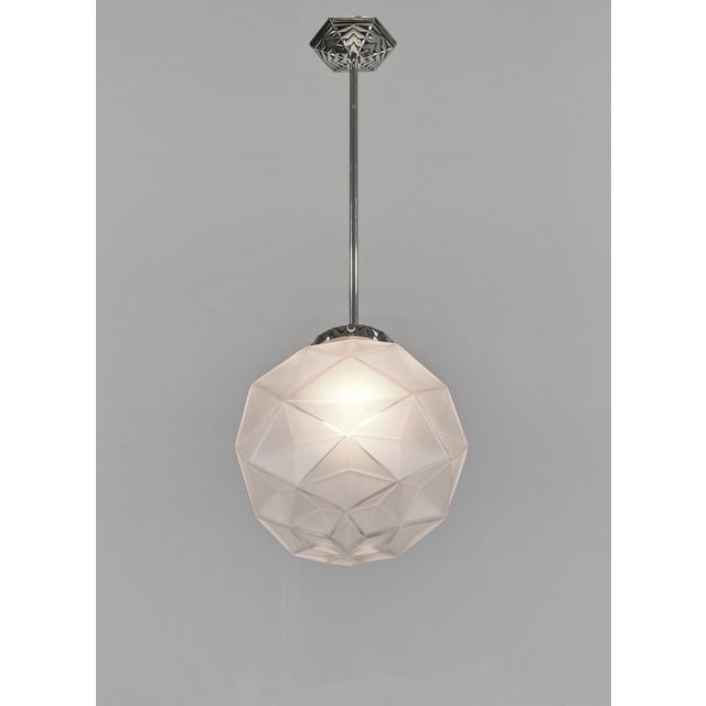 Degué A French 1925-1935 art deco pendant light in nickel plated bronze. The mounting holds a nice ball shaped shade in...