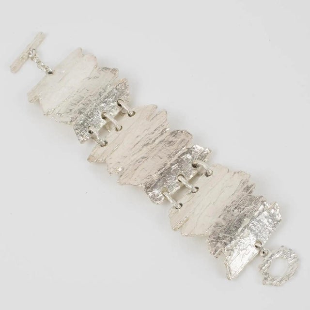 This stunning modernist silver plate link bracelet by Nelly Biche de Bere, Paris, features a chunky, oversized bangle with...