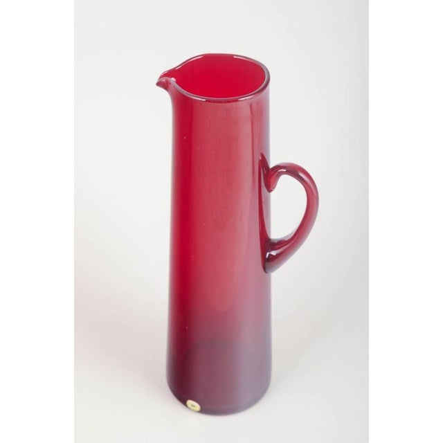 Monica Bratt for Reijmyre Pitcher, 1950s. Tall cylindrical art-glass pitcher in deep ruby-red glass with a gracefully...