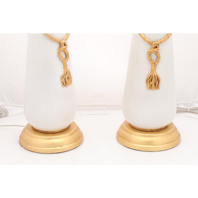 A signed pair of Italian Marbro table lamps featuring sculptural matte white ceramic bodies accented with gilt metal rope-...