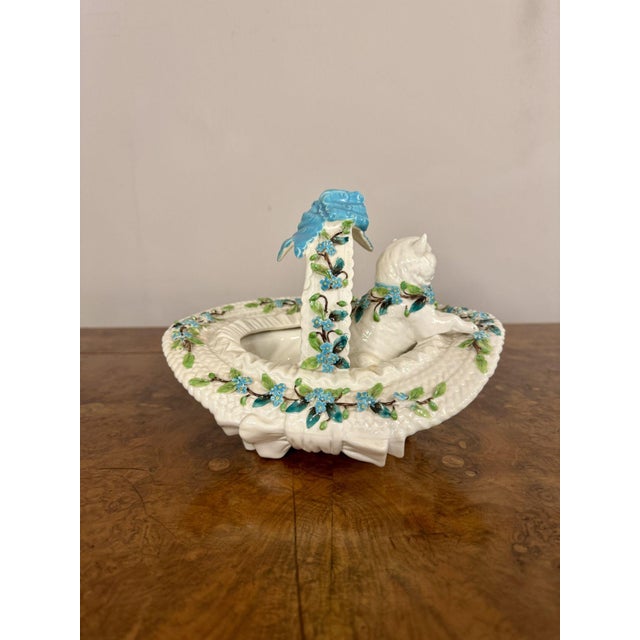 Pretty quality antique Victorian porcelain basket, having a quality white cat with a blue bow in a seated position sitting...