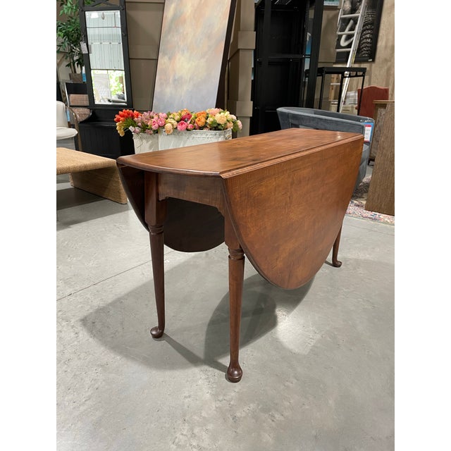 An early 18th century drop-leaf dining table, beautifully crafted from richly figured tiger maple. The rectangular center...