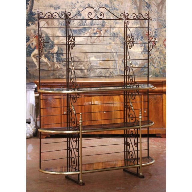 This tall antique baker’s rack combines graceful French ironwork with warm brass accents and practical display space....