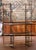 This tall antique baker’s rack combines graceful French ironwork with warm brass accents and practical display space....