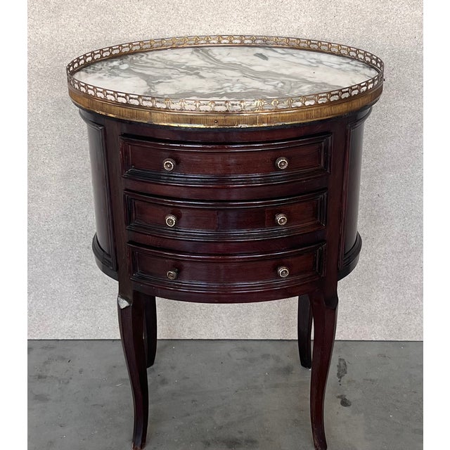 French Louis XVI style side table or nightstand topped with marquetry top, fluted legs finished with golden bronze clogs....