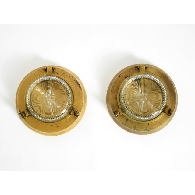 Two heavy 1950s round original ship wall lamps made of solid brass with glass shades. Beautiful nautical design. with...